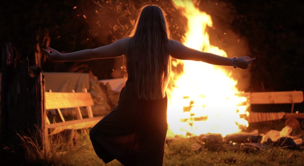 Mädchen in Yoga Position am Lagerfeuer beim Irie in the Woods